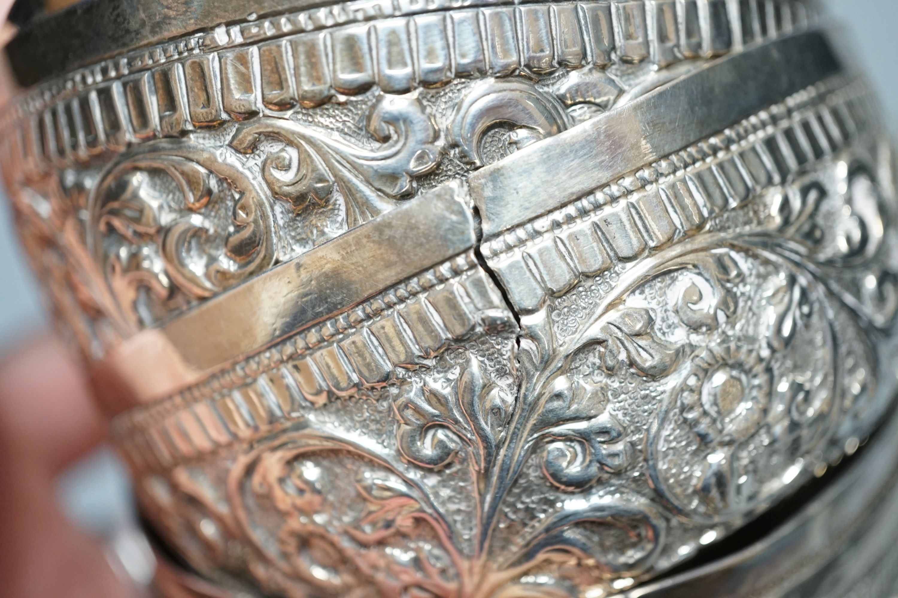 Four small Rangoon white metal bowls together with a simile basket and six small white metal bowls with heraldic motifs, gross 24.5oz.